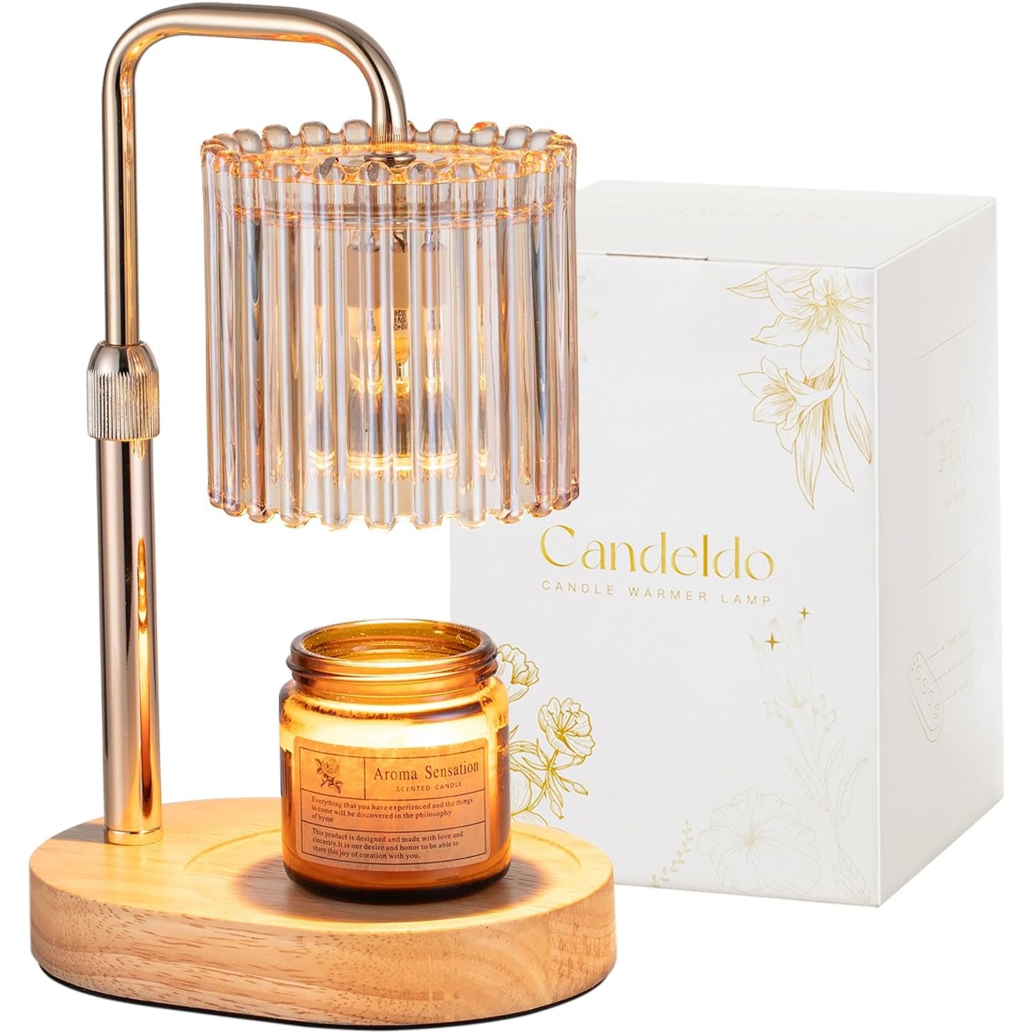 Gold candle warmer lamp with a ribbed amber glass shade lit over a jar candle, shown beside its white gift box